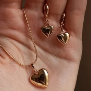 Un ensemble de trois colliers et boucles d'oreilles pendentifs en forme de cœur, élégants et minimalistes, parfaits pour les fêtes ou au quotidien.